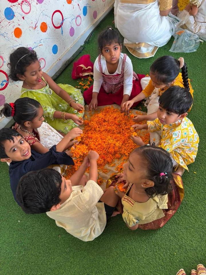Children making a marigold petal rangoli