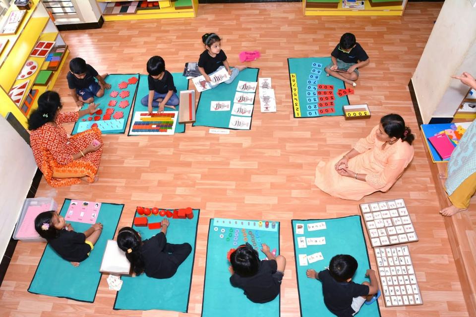 Children working with Montessori materials on mats